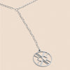 Silver necklace with a round pendant on a beige background